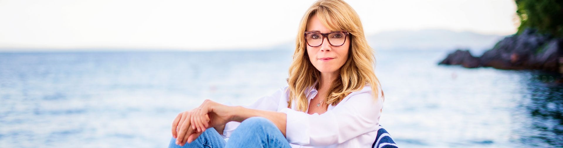 Woman at lake, looking at camera.