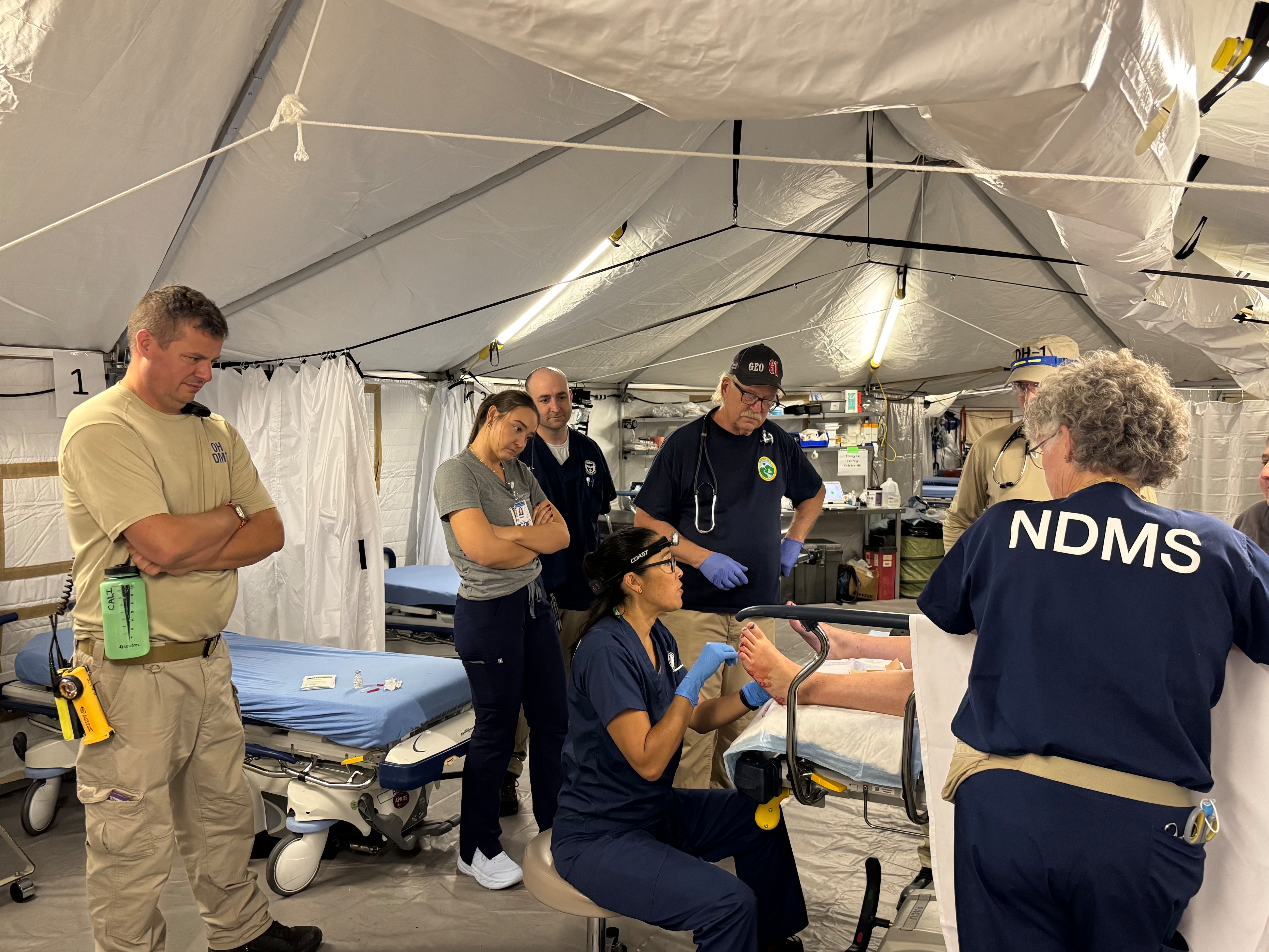 Medical staff look at a patient injury.