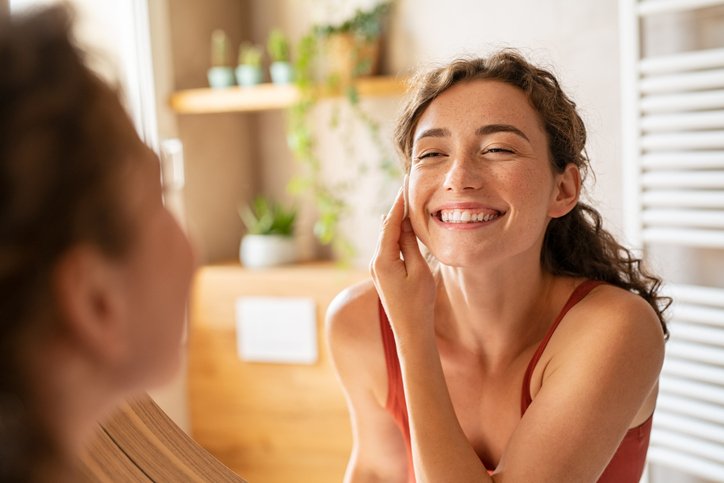 Woman putting lotion on face